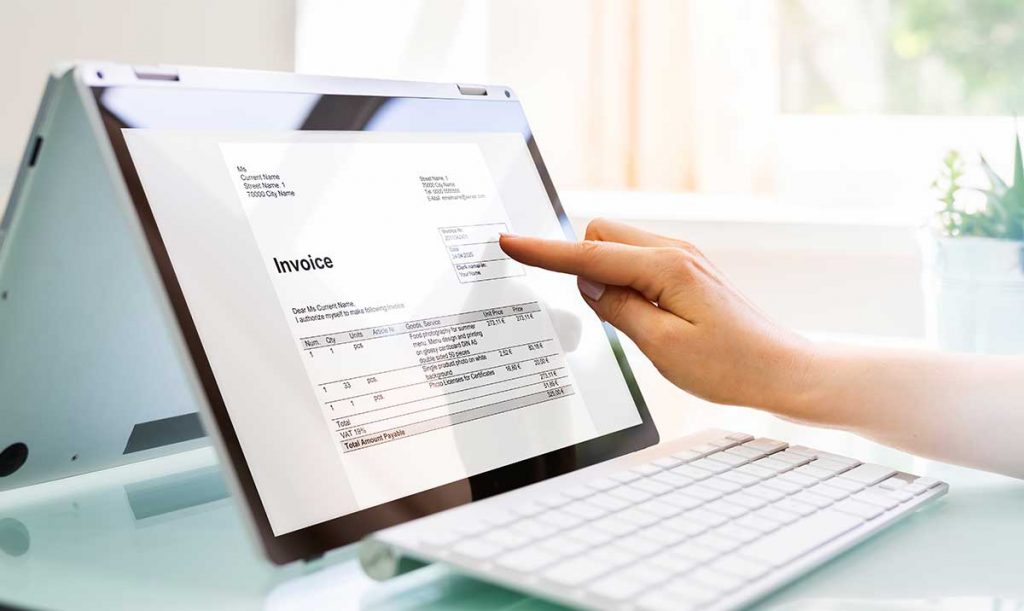 Primo piano delle mani di una donna d'affari che lavora sulla fattura sul computer portatile con tecnologia touch