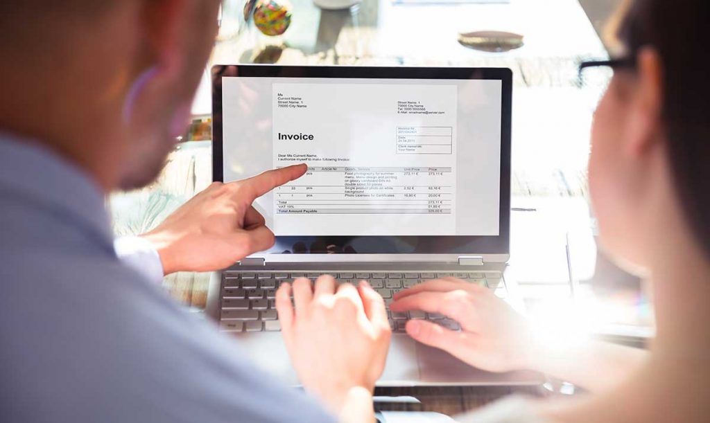 Un uomo ed una donna ripresi di spalle mentre consultano una fattura elettronica dal computer portatile