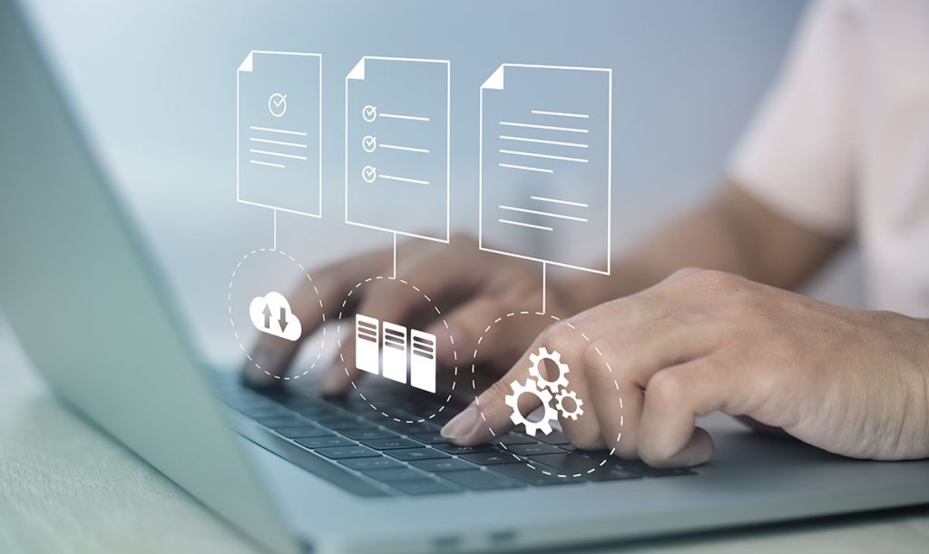 Primo piano delle mani che digitano sulla tastiera di un computer e icone sullo schermo virtuale.