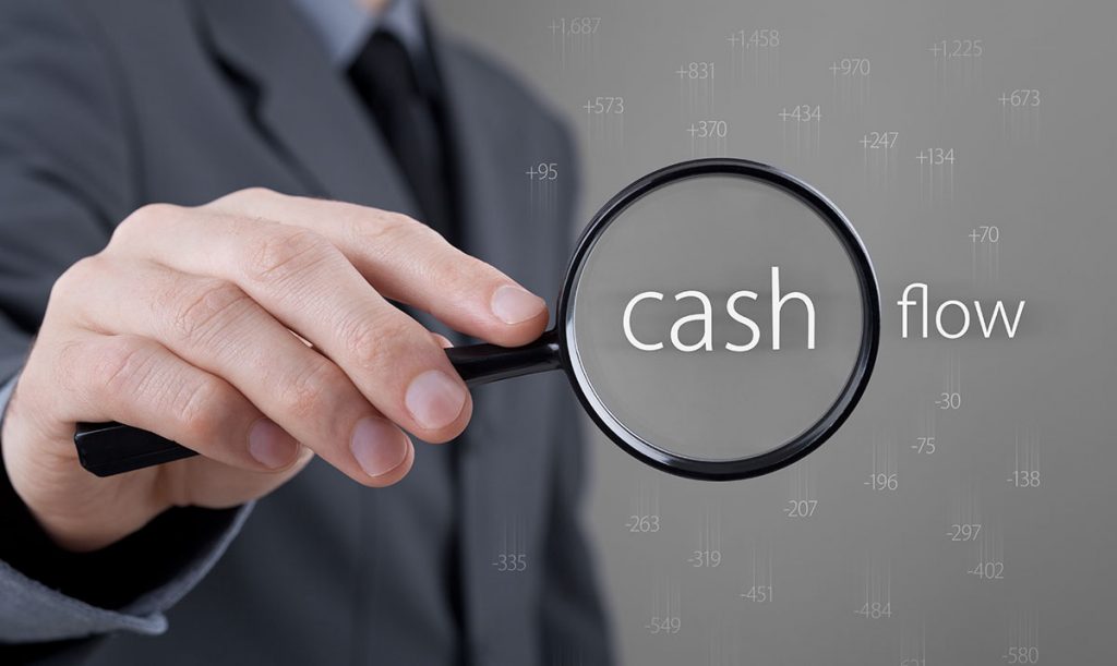 Primo piano della mano di un uomo d'affari che regge una lente di ingrandimento sul testo Cache Flow