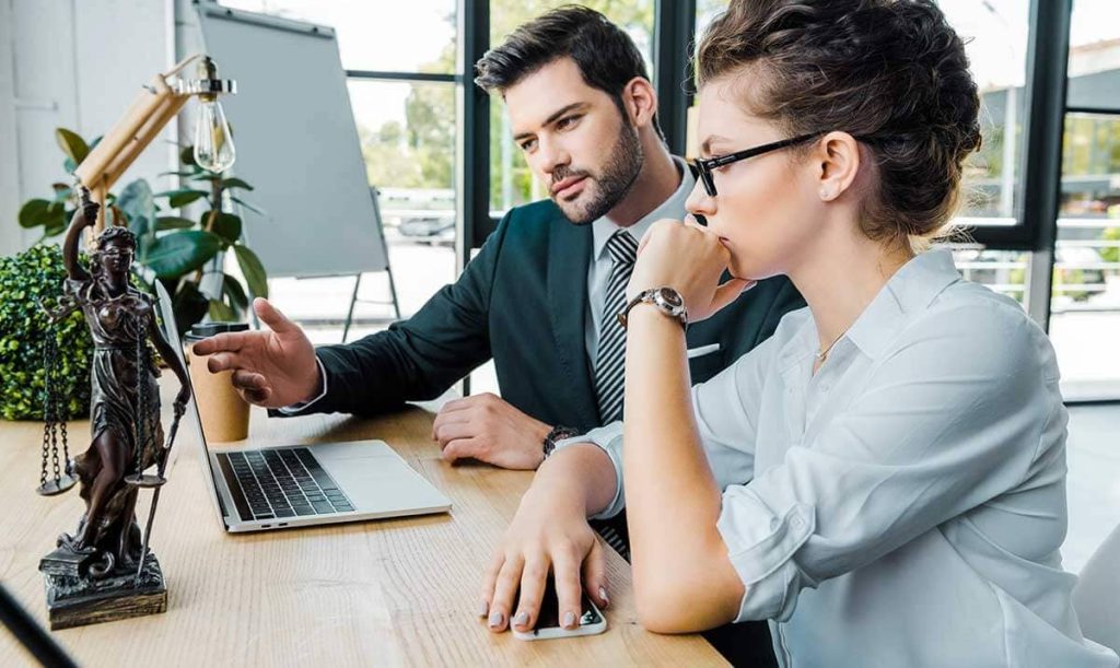 Avvocati alla scrivania consultano il pc