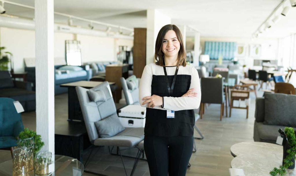 Ritratto di una splendida giovane donna che lavora come rappresentante di vendita in un bellissimo negozio di mobili