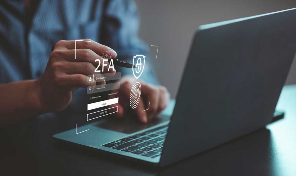 Persona che utilizza un laptop e tocca lo schermo virtuale per l'autenticazione a due fattori per l'accesso ai suoi dati in cloud