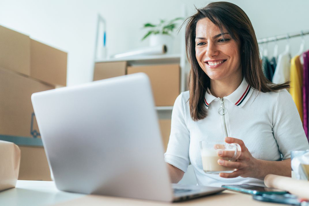 Giovane imprenditrice nel regime forfettario lavora al pc utilizzando Kubik, software di fatturazione elettronica per professionisti